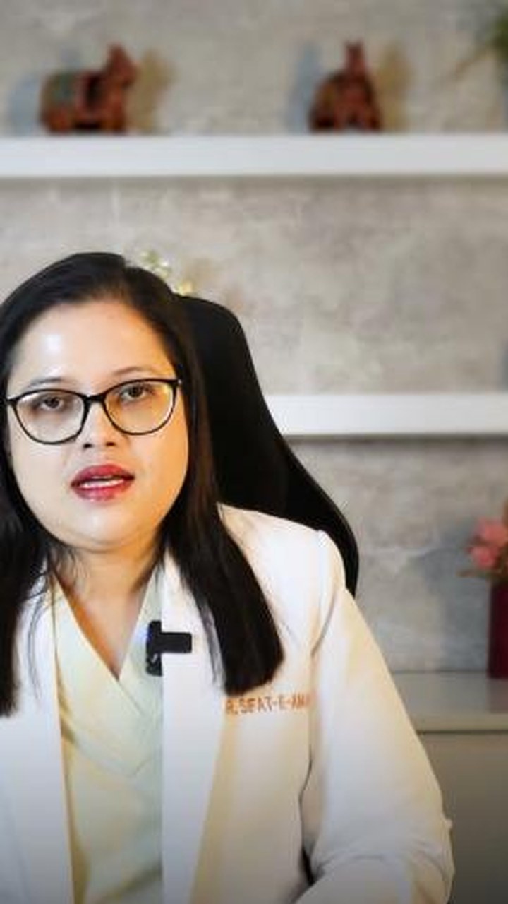 Dr. Sifat-E-Aman seated at her desk in a white coat, speaking to camera.