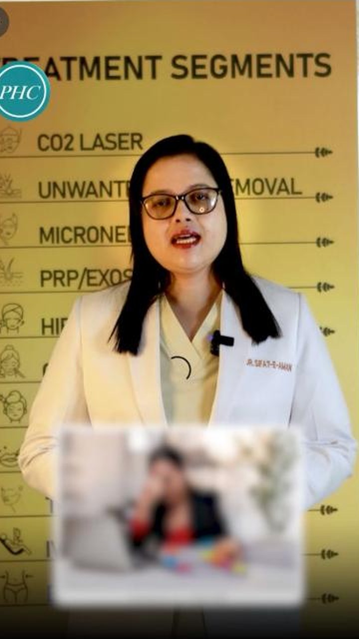 Dr. Sifat-E-Aman in her white coat speaking to camera in front of a treatment-list board.